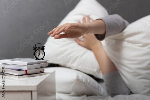 daily routine concept woman wakes up at 7 am and turns off the alarm  laziness