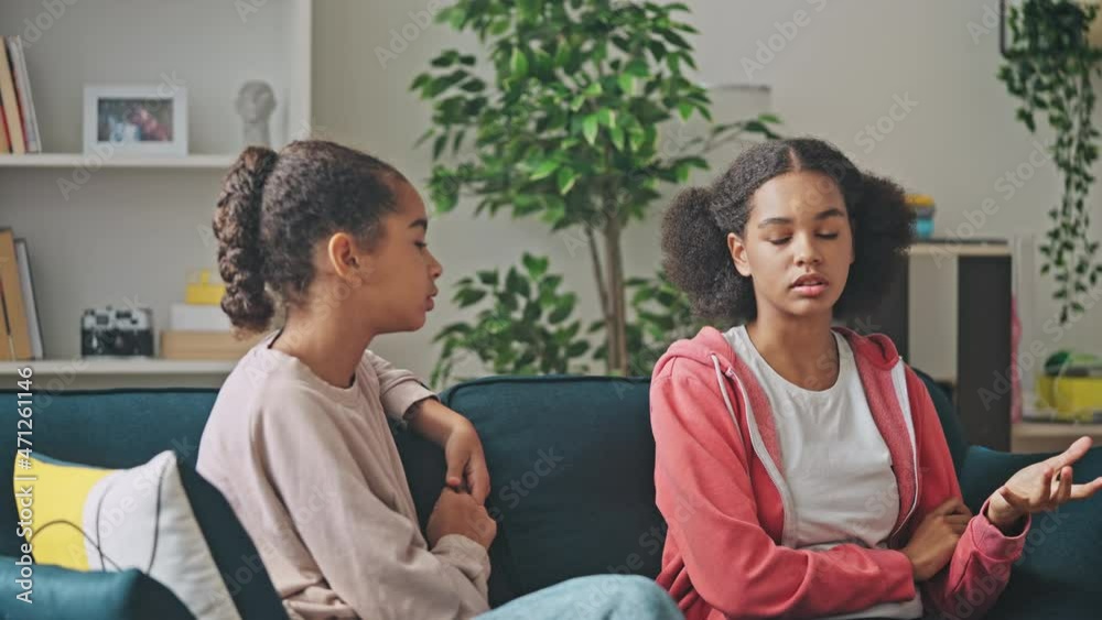 Serious african american teen girls discussing problem, conflict between friends Serious african american teen girls discussing problem, conflict between friends