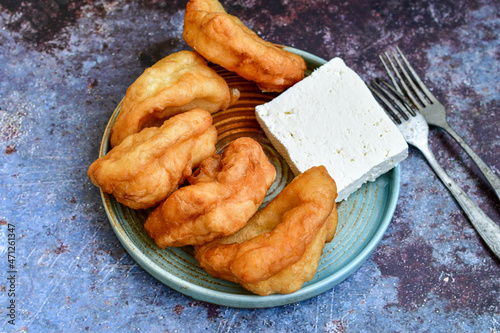 Traditional Bulgarian home made deep fried  patties  covered with sugar  оn rustic backgroud.Mekitsa or Mekica,  on wooden  rustic  background. Made of kneaded dough that is deep fried  photo