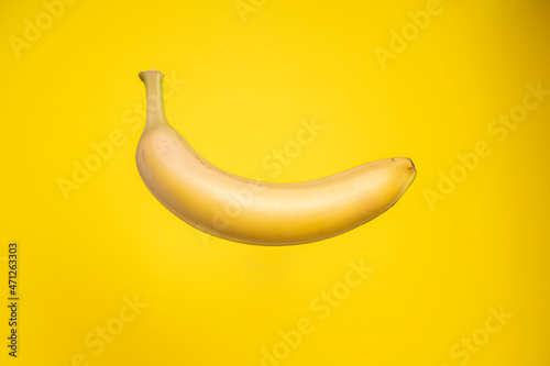 Delicious fresh banana with shadow on yellow background.