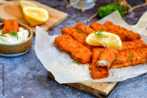  Fish and chips.Close up of crispy breaded deep fried alaska pollock fillets with breadcrumbs served with remoulade sauce french fries and lemons