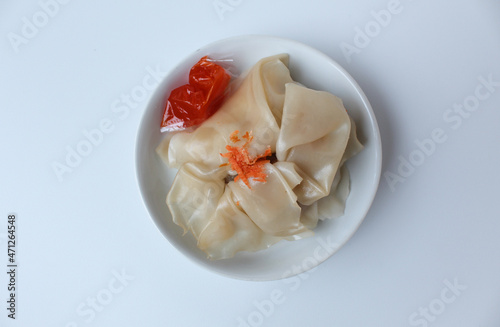 Affordable version of dumplings, with a small packet of sauce. Isolated on white background photo