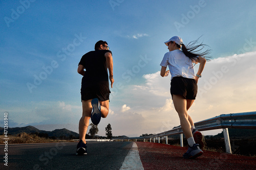 Two runners are running on the road.