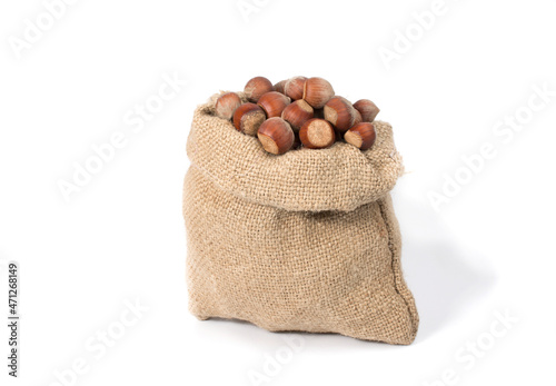 Fresh hazelnuts in a burlap bag, isolated on a white background.