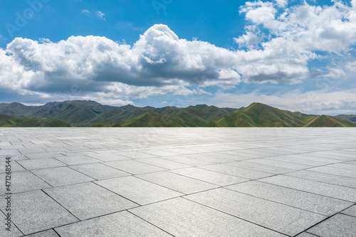 Empty square floor and mountains under blue sky