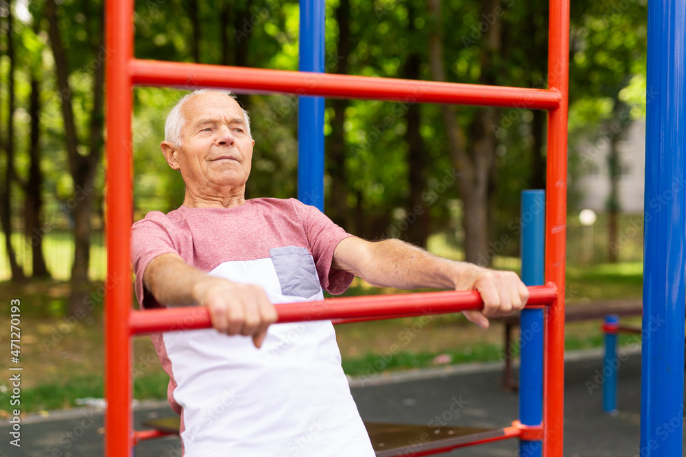 Fototapeta premium Senior man training on vertical ladder outdoors