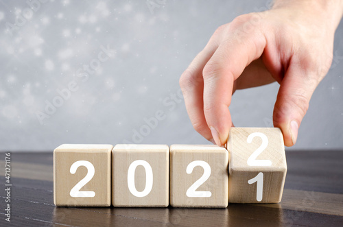 Hand Turns over the wooden cube to change from 2021 to 2022. New 2022.