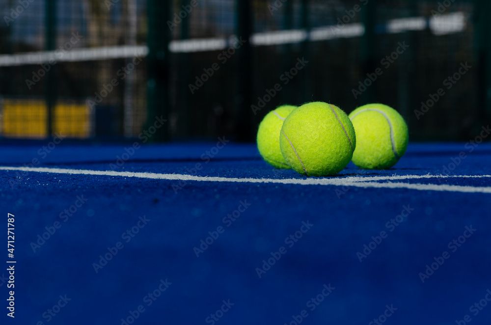 three balls on a paddle tennis court, selective focus