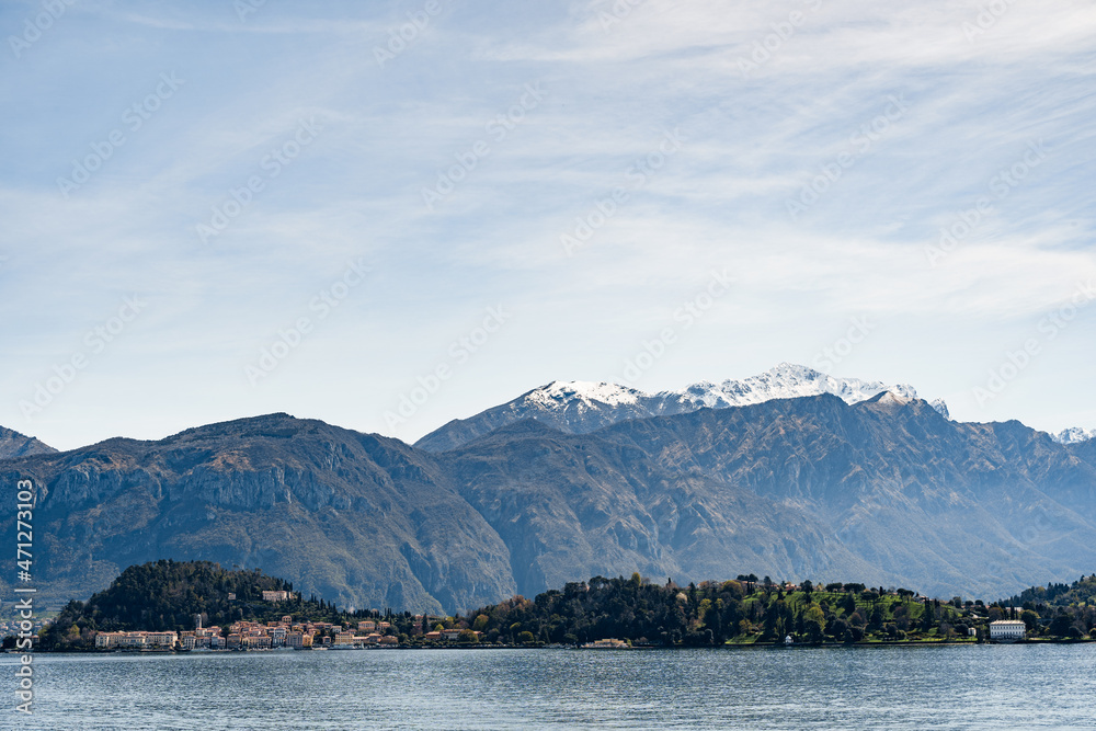 View from Lake Como to houses on the coast against the backdrop of mountains. Bellagio, Italy