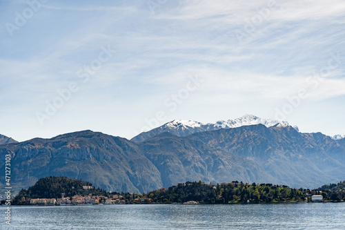 View from Lake Como to houses on the coast against the backdrop of mountains. Bellagio, Italy