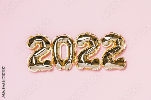New year 2022 balloon celebration card. Gold foil helium balloon number 2022 isolated on pink background. Flat lay, merry christmas, happy holidays mockup.
