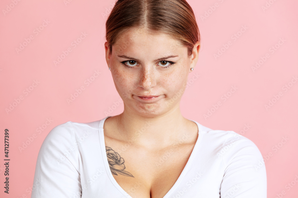 Close-up portrait of young beautiful girl with cute freckles isolated on pink studio background in neon light. Close-up portrait of young beautiful girl with cute freckles isolated on pink studio background in neon light.