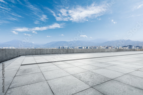 Empty square floor and modern city commercial building with skyline