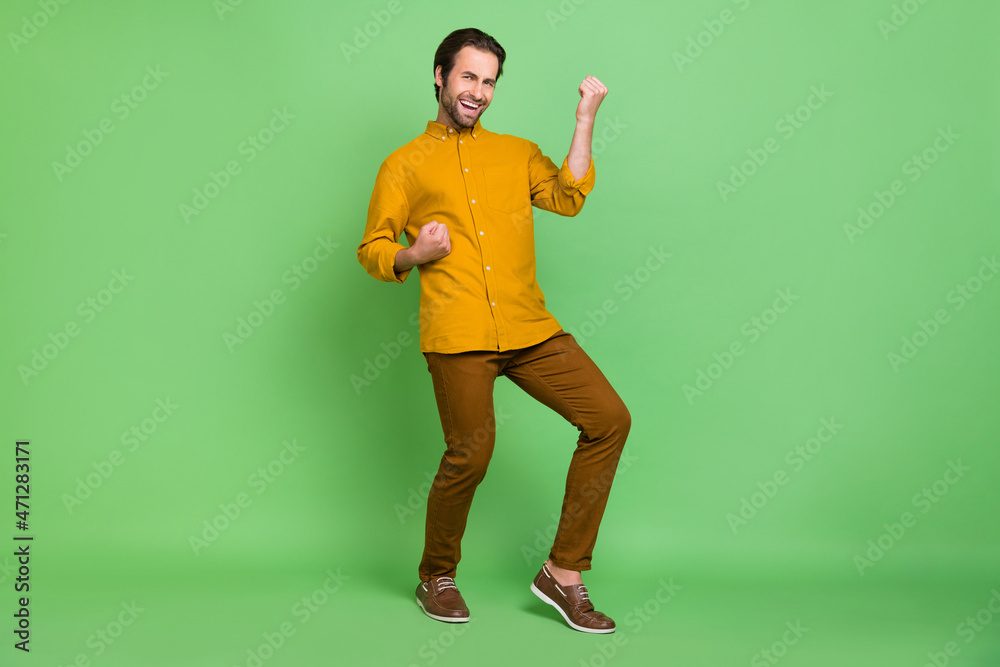 Full length photo of cool millennial guy yell wear shirt trousers shoes isolated on green color background Full length photo of cool millennial guy yell wear shirt trousers shoes isolated on green color background