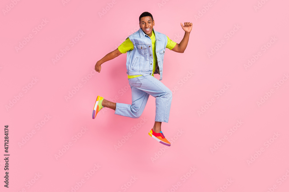 Full size profile photo of cool young brunet guy run wear t-shirt vest jeans gumshoes isolated pink background