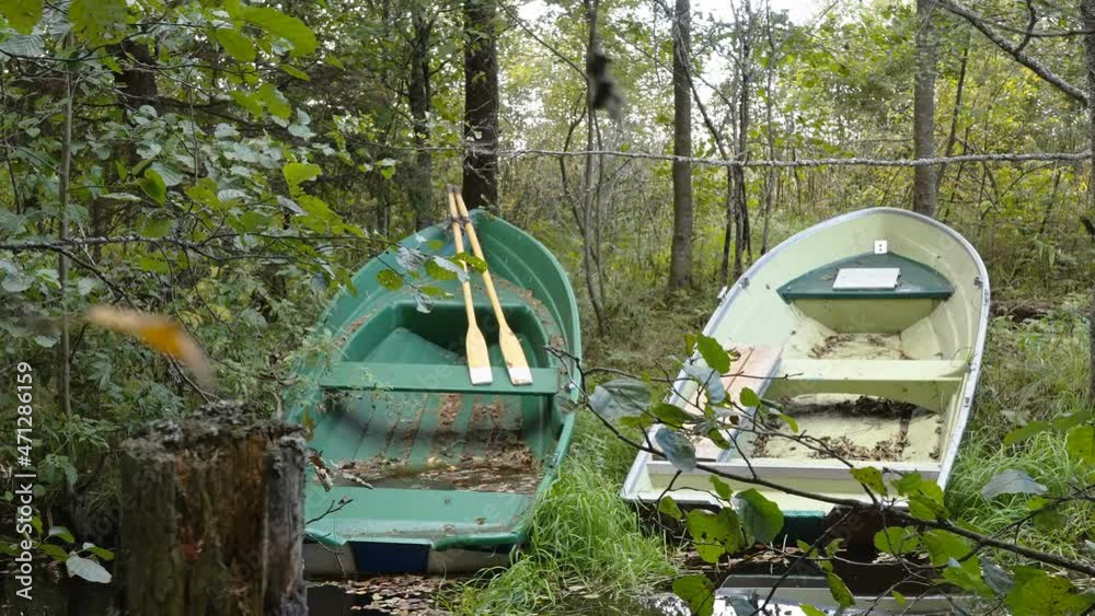 Two abandoned boats on the side of the trees in the forest lake in Estonia Two abandoned boats on the side of the trees in the forest lake in Estonia