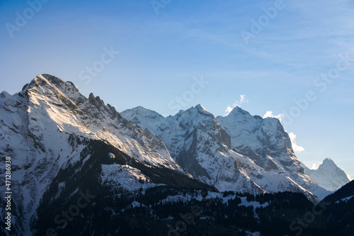 intense mood mountain range in switzerland alps  strong clouds and bright light at midday