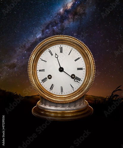 An old antique watch on a pedestal on a starry night sky background