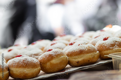 fried and stuffed sufganiot with strawberry jam, displayed for sale at the Mahane Yehuda market in Jerusalem, Hanukkah photo