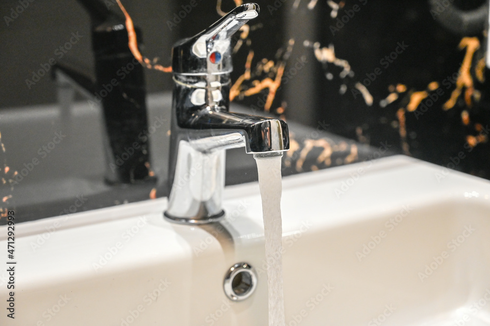 Drinking water flows from the tap. Faucet in the bathroom at home