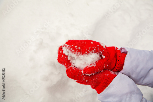 white snow on red mittens