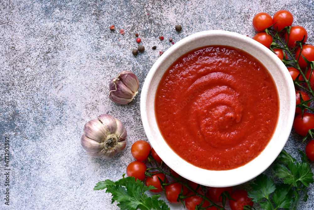Homemade spicy tomato sauce with ingredients for making . Top view with copy space. Homemade spicy tomato sauce with ingredients for making . Top view with copy space.