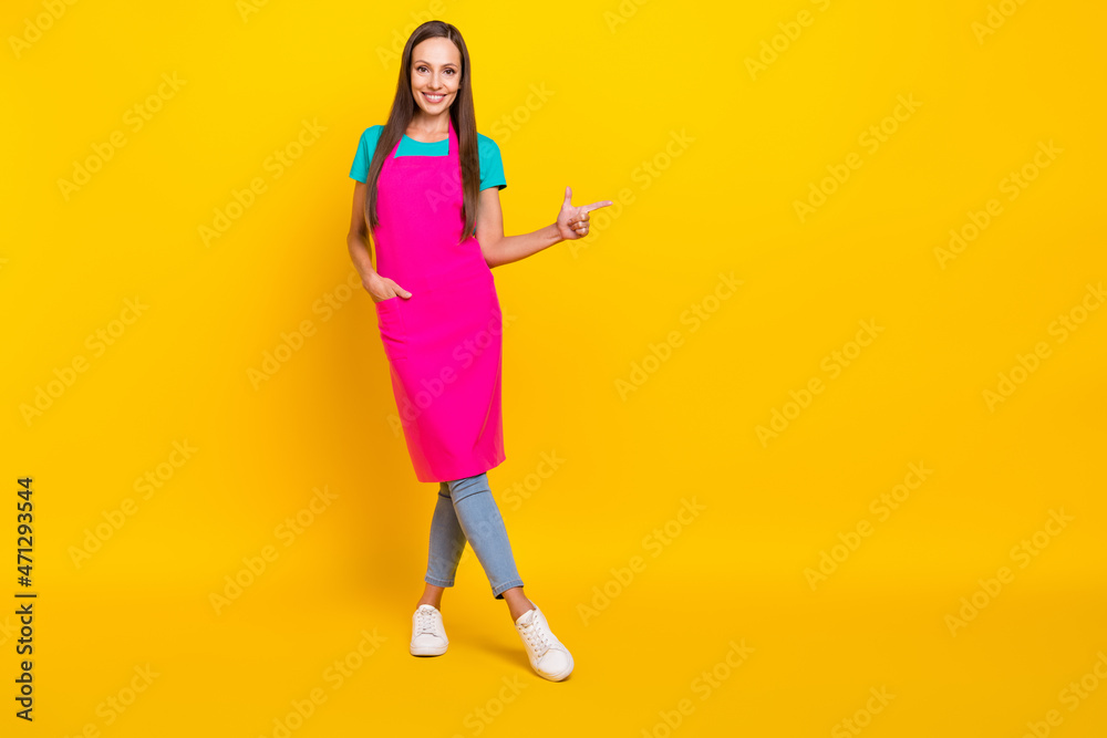 Photo of reliable promoter waitress lady direct finger empty space wear pink apron isolated yellow color background Photo of reliable promoter waitress lady direct finger empty space wear pink apron isolated yellow color background