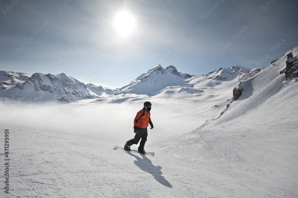 snowboarder in wonderful winter sports scene in the alps. with snowboard and ski in fantastic mountain panorama with snow.