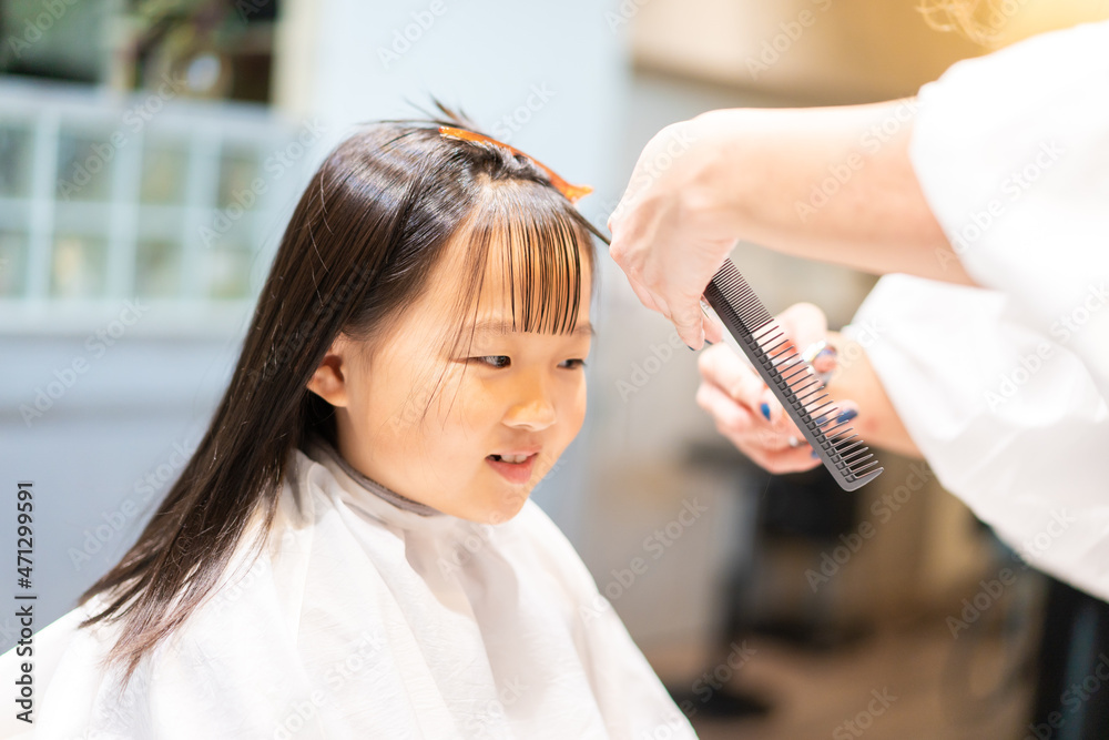 Naklejka premium 美容室でヘアカットをする女の子