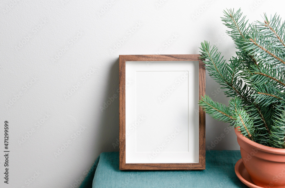 Photo frame mockup with fir tree branches in terracotta pot Photo frame mockup with fir tree branches in terracotta pot