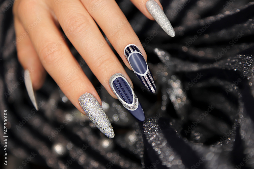 Manicure on long shaped nails with blue and silver top coating.