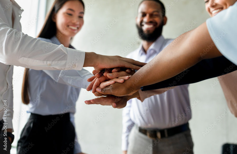 Fototapeta premium Corporate Traditions. Group Of Happy Multiethnic Collagues Stacking Hands Together
