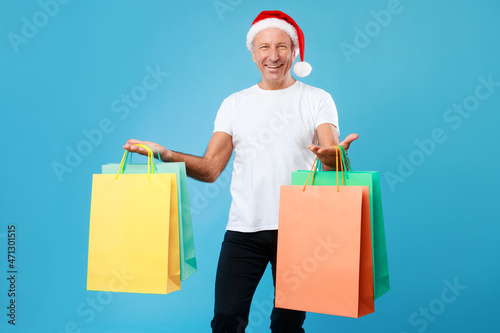 Cheerful man holding shopping bags at studio. Xmas Sales