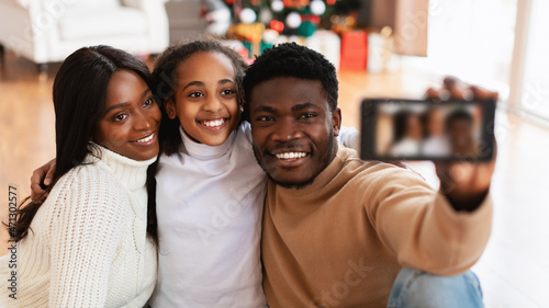 Happy black family taking selfie on Xmas