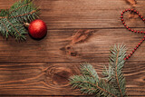 Christmas background with fir sprig and red toys on wooden boards.