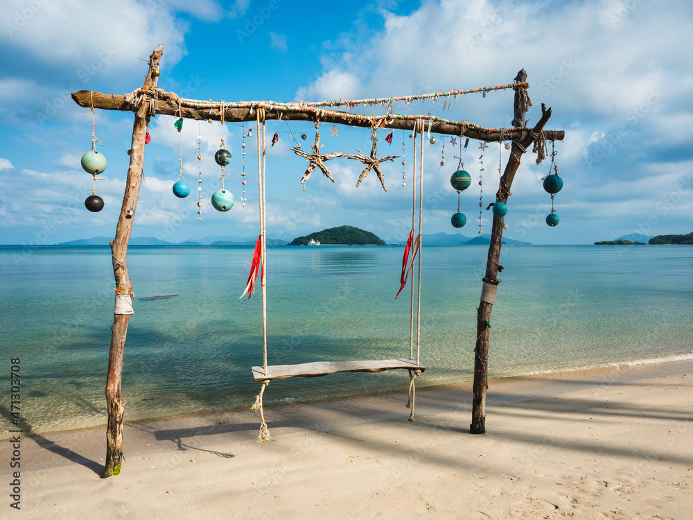 Scenic view of tropical paradise island with relax wooden beach swing and clear turquoise sea against blue sky in summer. Koh Mak Island, Trat, Thailand.