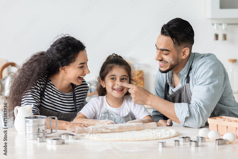Cheerful family having fun while making biscuits at home Cheerful family having fun while making biscuits at home