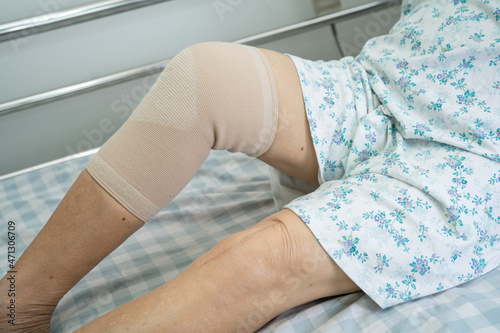 Asian senior or elderly old lady woman patient with knee support pain joint on bed in nursing hospital ward  healthy strong medical concept.