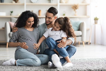 Happy middle eastern family posing together, waiting for baby