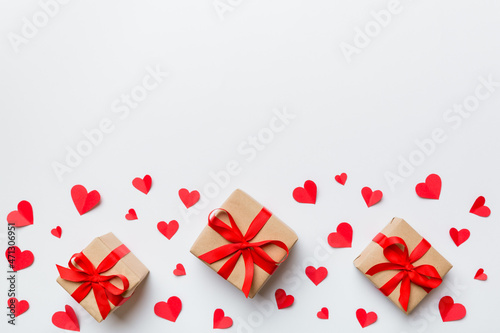 Valentine day composition  red gift box with bow and heart. Christmas present. View from above. Space for text. Holday greeting card