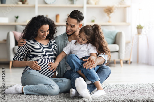 Happy middle eastern family posing together, waiting for baby