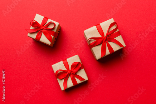 Valentine day composition Background: red gift box with bow and heart. Christmas present. View from above. Holday greeting card © sosiukin