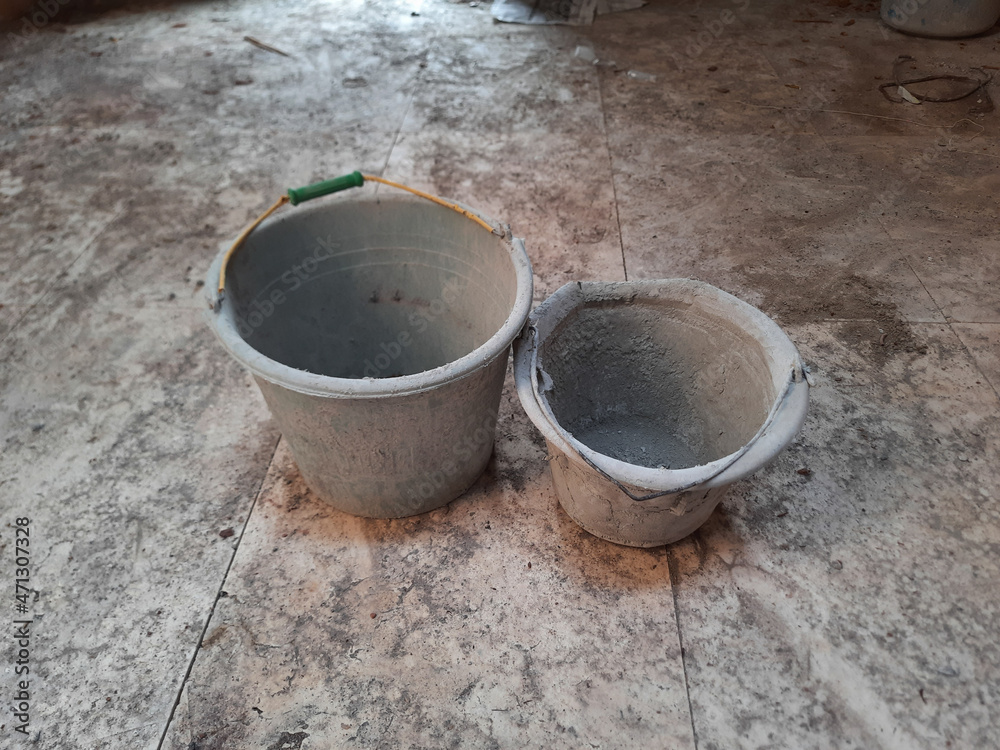 Used construction buckets, covered by dry cement. Buckets for mixed cement.