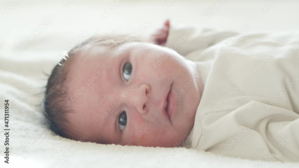 Close-up portrait of a young baby who has recently been born. Newborn infant boy at home. Window light. Close-up portrait of a young baby who has recently been born. Newborn infant boy at home. Window light.