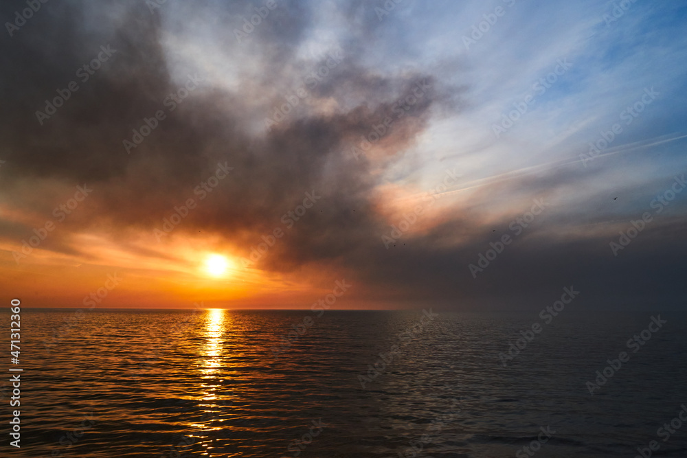 Sea sunset. Smoke wildfires sweeping across the sky.