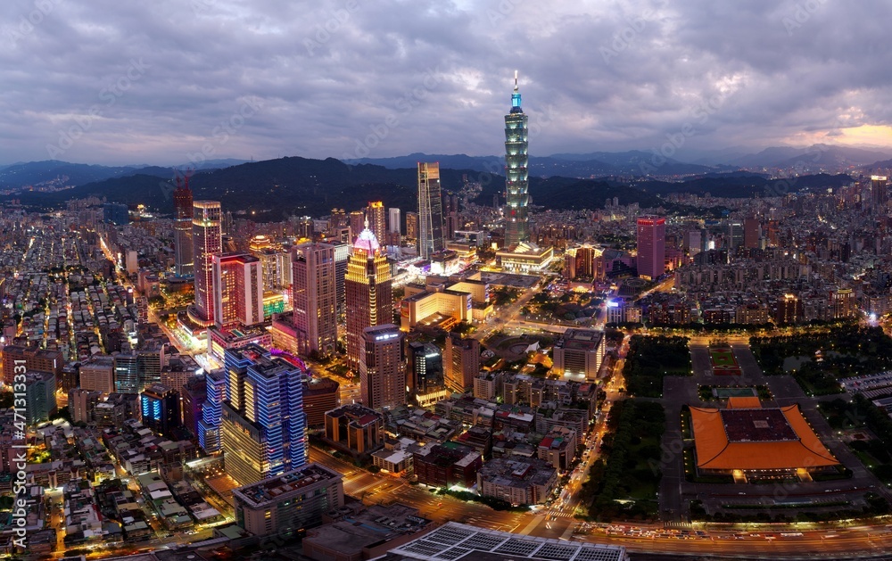 Obraz premium Aerial panorama of Downtown Taipei at dusk, the vibrant capital of Taiwan, with 101 Tower standing out among skyscrapers in Xinyi Commercial District and city lights dazzling under blue twilight sky