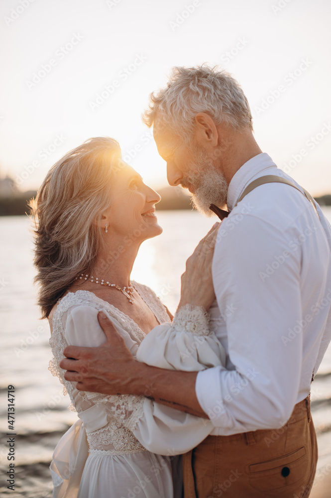 Happy elderly couple in wedding dress looking at each other in sun. Happy elderly couple in wedding dress looking at each other in sun.