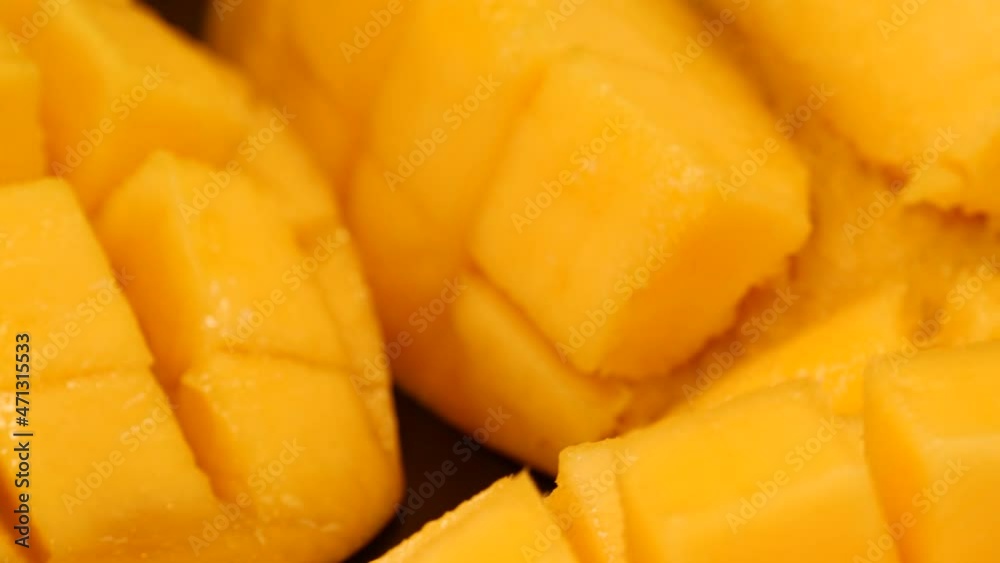 Mango on a black background. Ripe and organic mango cubes rotating on a black background. Tropical, exotic fruit. Mango on a black background. Ripe and organic mango cubes rotating on a black background. Tropical, exotic fruit.