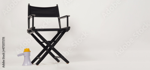 Black director chair and megaphone on white background.