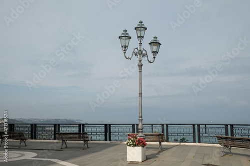 panorama with isolated iron lamppost and railing with benches
